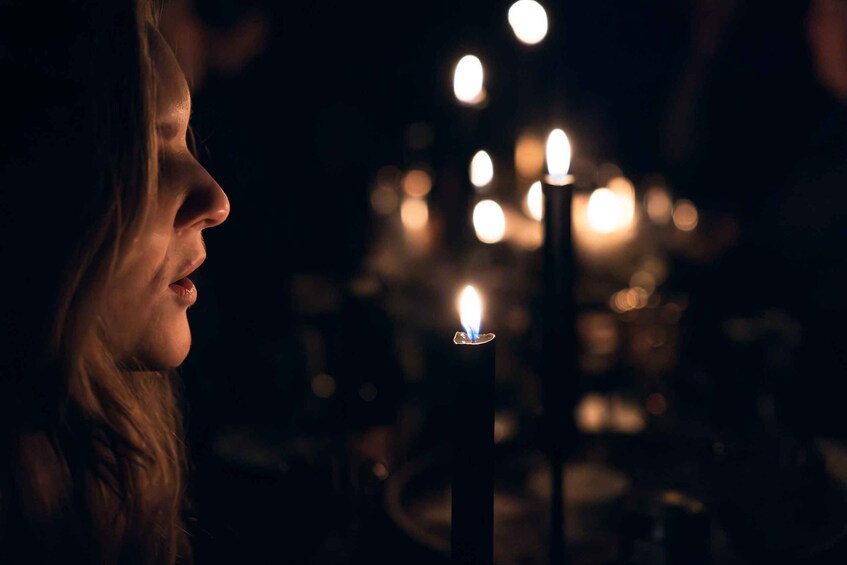 A candle with a flame in a dark setting. 3