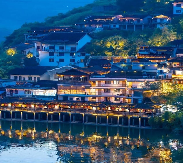 A waterfront village with traditional architecture, reflecting lights on the water. 2