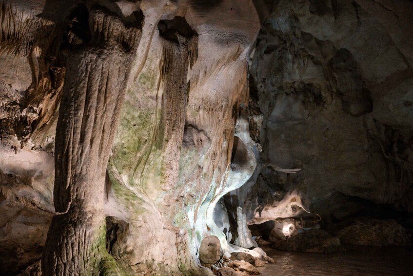 A cave with stalactites and stalagmites, illuminated by artificial lighting. 5