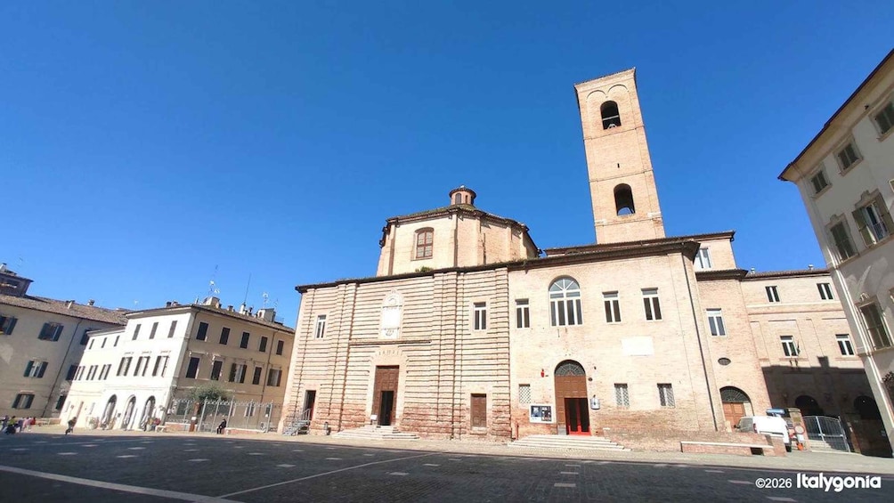 A historic building with a bell tower, a large arched entrance, and a clear blue sky. 1