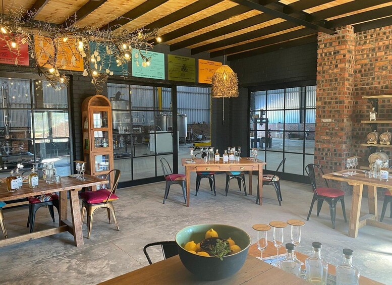 A rustic interior with wooden tables, chairs, and a large bowl of lemons. 1
