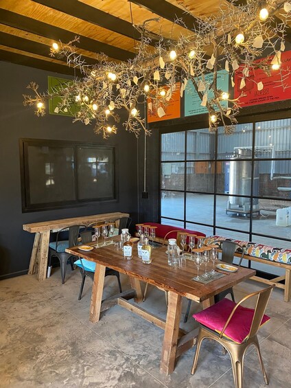 A rustic dining area with a wooden table, chairs, and a hanging light fixture. 4