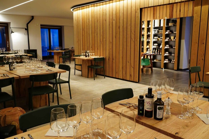 A restaurant interior with wooden tables, chairs, and wine glasses. 2