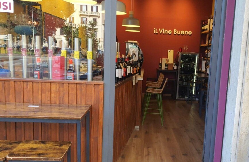 A bar with wooden furniture and a red wall with the sign 'il Vino Buono'. 4