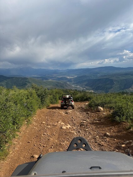 A jeep on a rocky path with a mountainous landscape in the background. 5