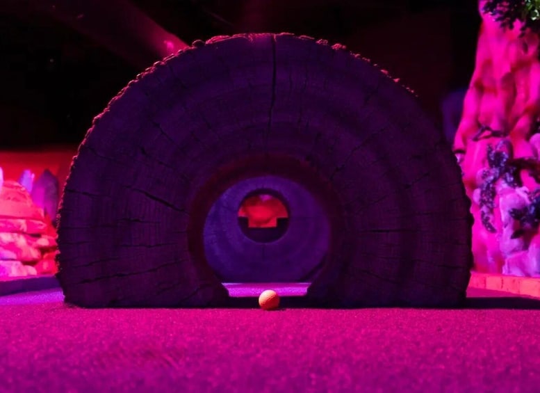 A tunnel with a glowing red center, surrounded by a purple-lit environment. 3