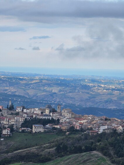 A town nestled in a valley with rolling hills in the background. 1