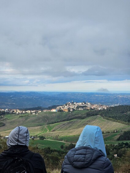Two people overlooking a town from a hilltop. 3