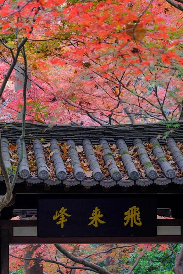 A traditional Japanese building with a tiled roof and a sign with Japanese characters. 1