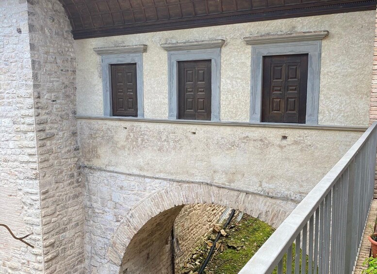 A stone building with three windows and an arched doorway. 5
