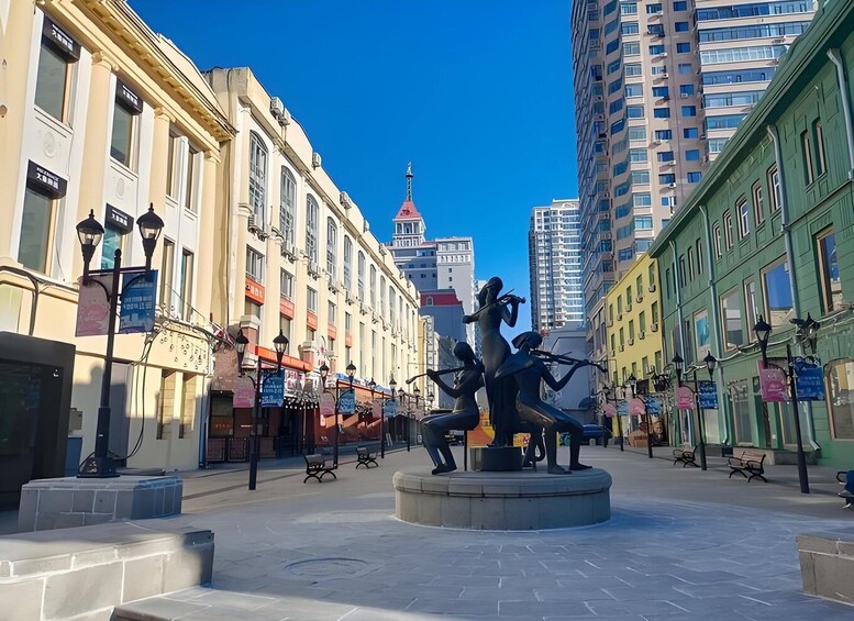 A public square with a central sculpture, surrounded by historic buildings and modern high-rises. 3