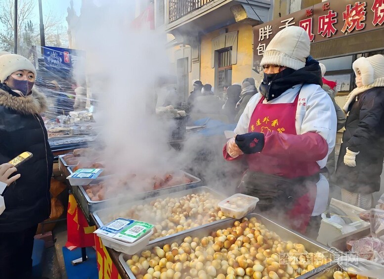 A street food vendor cooking at a stall with a crowd nearby. 5