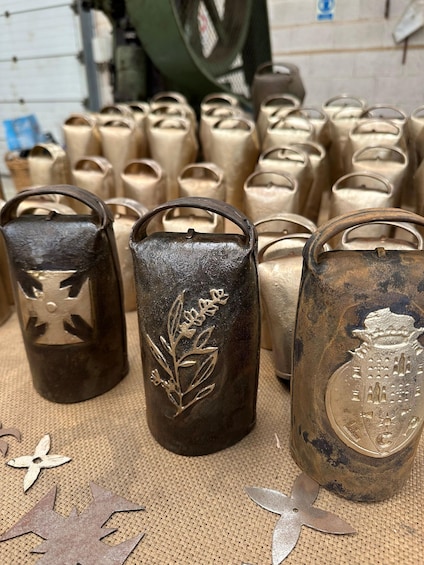 A collection of metal candle holders with embossed designs, arranged on a burlap surface. 5