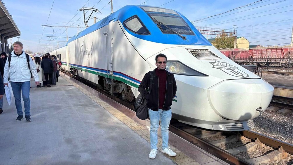 A high-speed train at a station platform with passengers waiting. 1