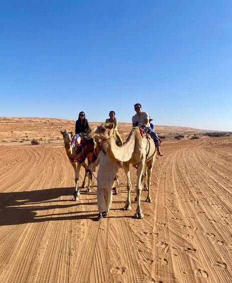 A desert landscape with camels and riders. 2