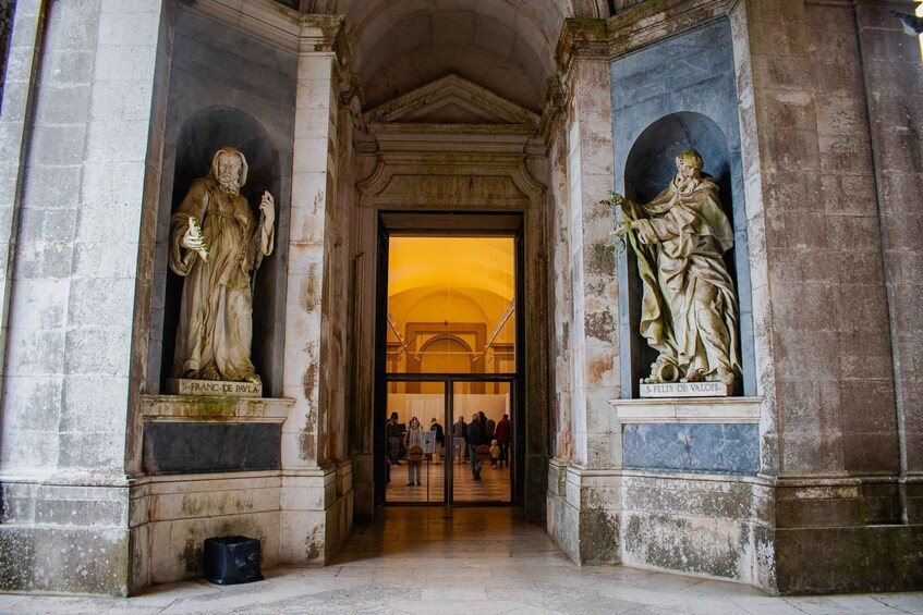 A historical building entrance with statues of S. Franc de Pauva and S. Felix de Valaos. 1
