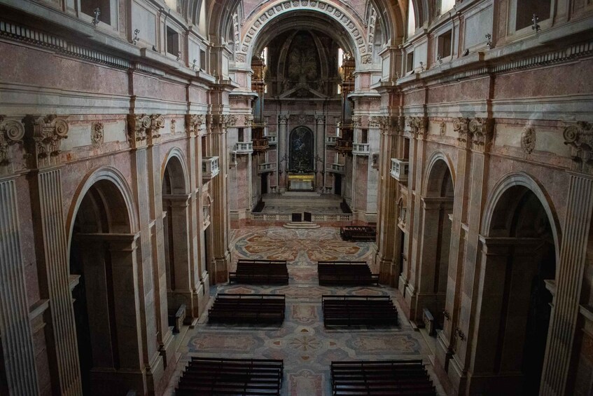 A grand hall with arched ceilings, intricate wall carvings, and a central altar. 4