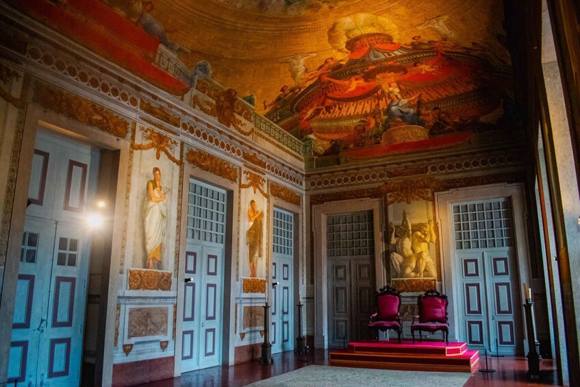 An ornate room with classical architecture, including columns, a frescoed ceiling, and statues. 3