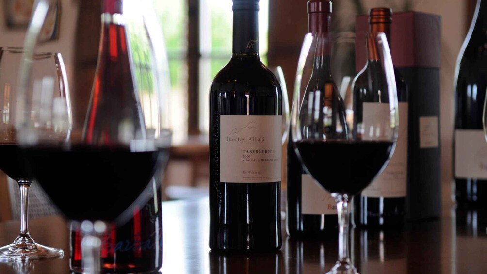 A selection of wine bottles and glasses on a table. 5