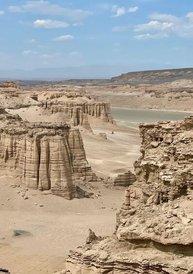 A desert landscape with layered rock formations and a river. 3