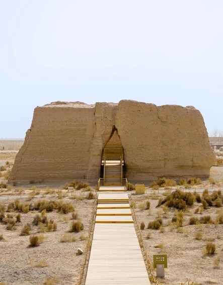 A large stone structure with a wooden walkway leading to an entrance. 5