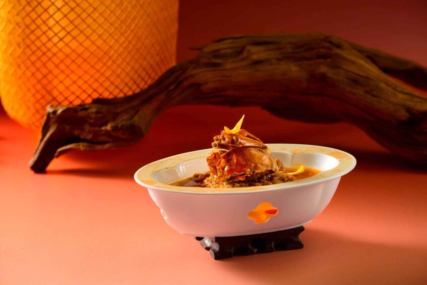 A bowl of crab with sauce on a table. 2