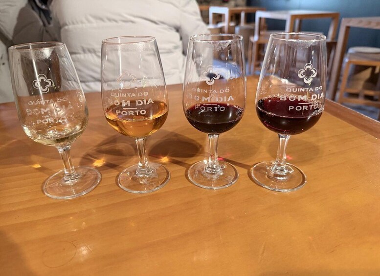Four wine glasses on a wooden table with embossed text. 1