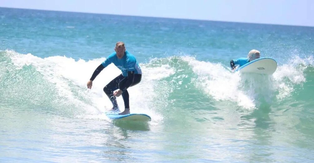 Two surfers riding waves in the ocean. 1