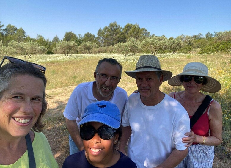 A group of people standing in a field with trees in the background. 1