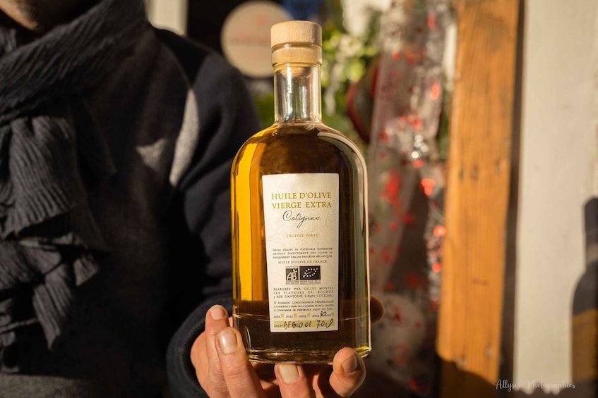 A person holding a bottle of HUILE D'OLIVE VIERGE EXTRA Cotignac. 5