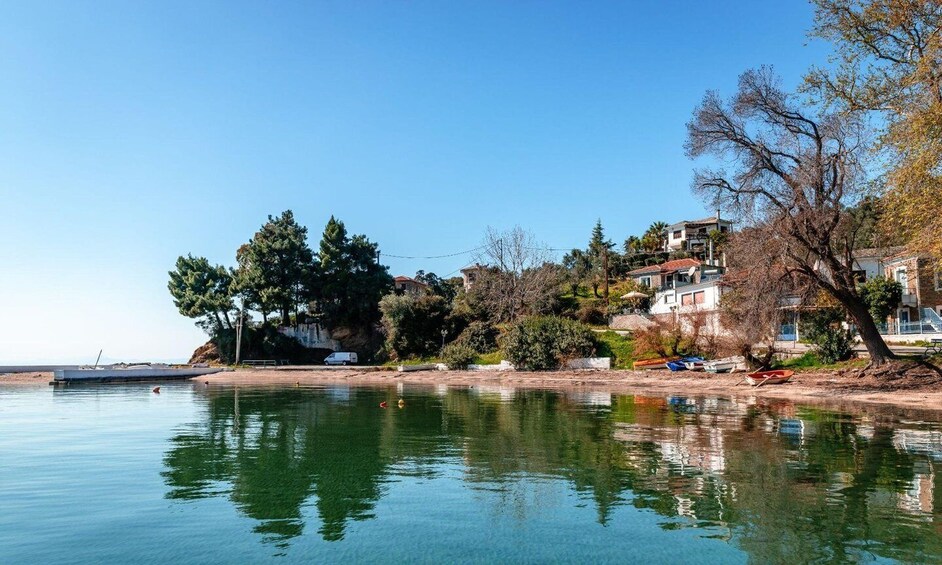 A calm lake with clear reflections, surrounded by trees and buildings. 4
