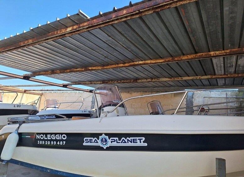 A boat named 'Sea Planet' with a registration number '389 20 99 487' docked under a metal roof. 2
