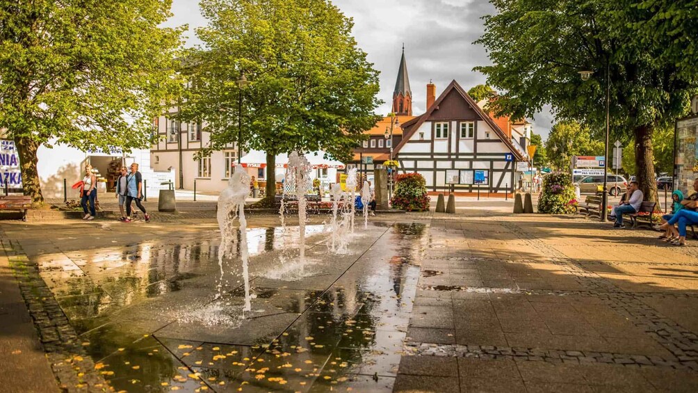 A public square with a fountain, trees, and traditional buildings. 4