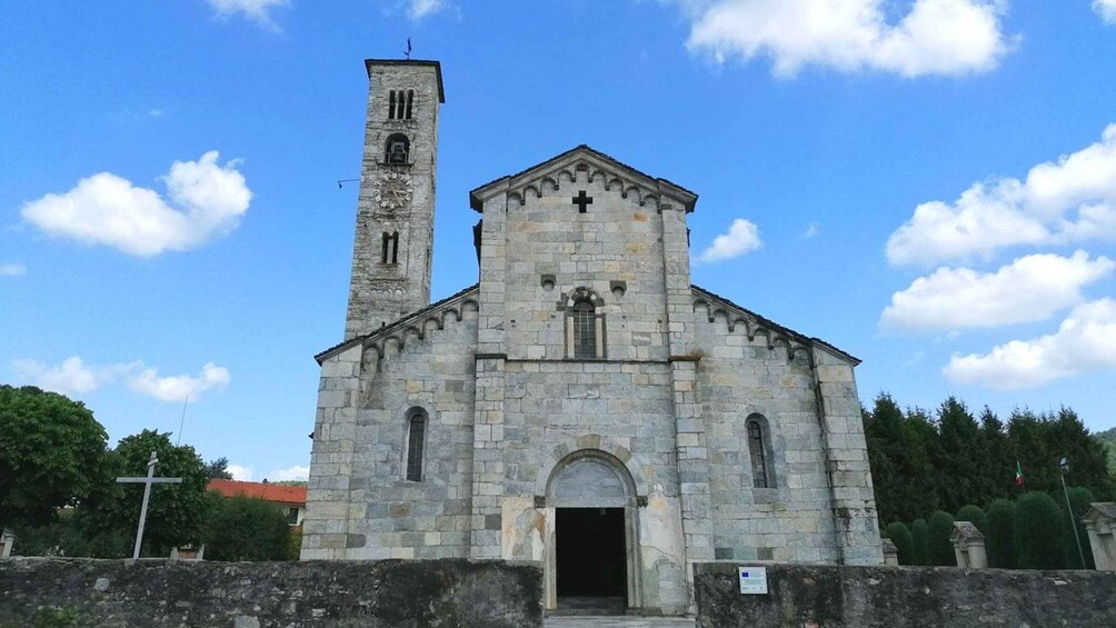 A stone church with a bell tower and a cross on the facade. 5