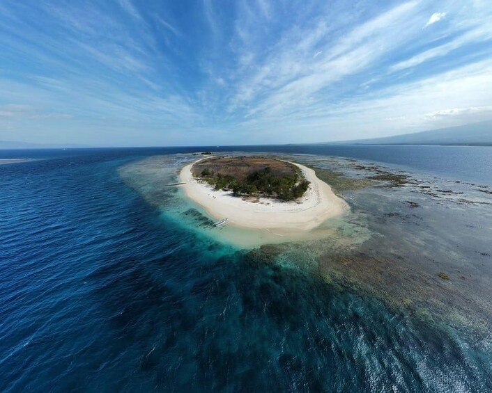 An aerial view of a small island surrounded by clear blue waters. 2