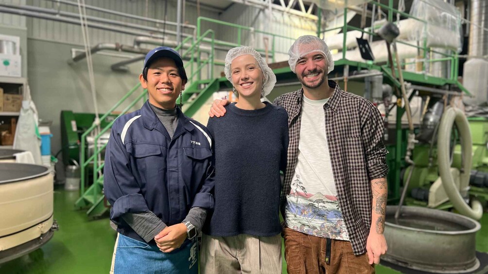 Three people in a workshop with industrial equipment. 4