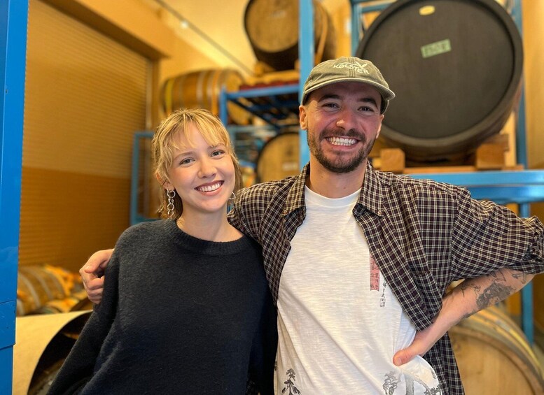 A person in a plaid shirt and a cap standing next to another person in a black sweater. 2
