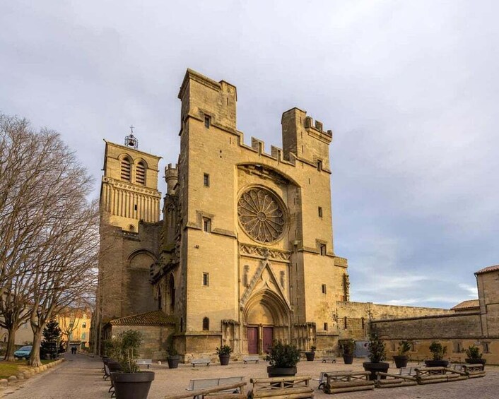 A historic stone building with a large circular window and a clock tower. 5