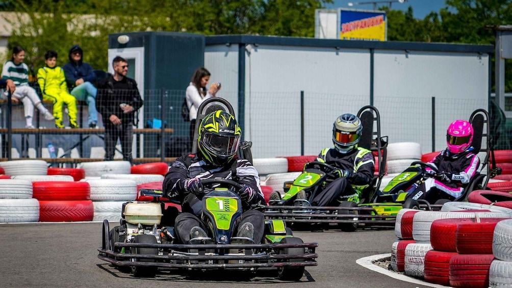 Go-kart racers on a track with spectators in the background. 5