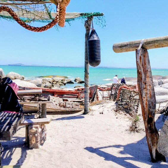 A beach with a netted area, a punching bag, and a rocky shoreline. 2