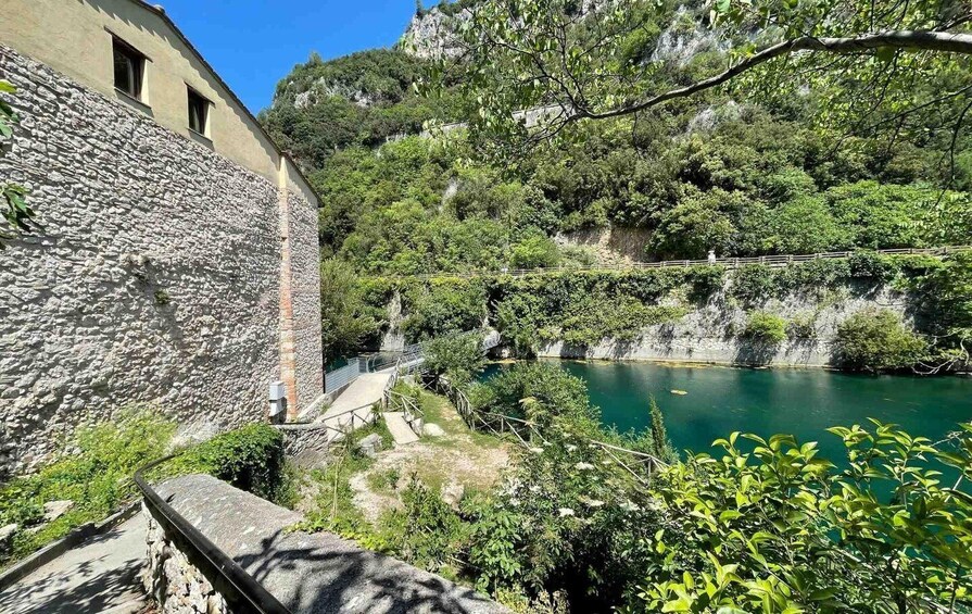 A stone building, a river, and a forested hillside. 2