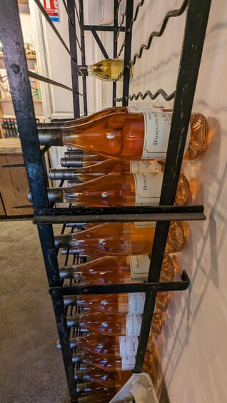 A rack of wine bottles with labels, some with visible text. 3
