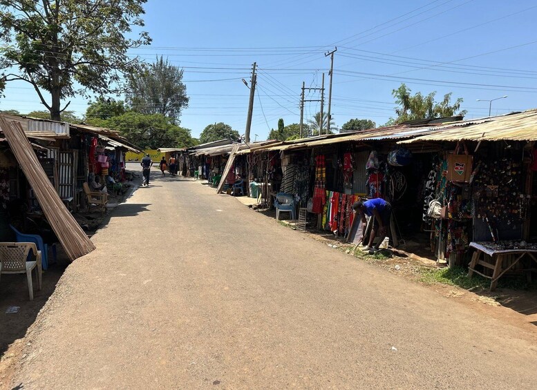 A rural street lined with small shops and stalls selling various goods. 4
