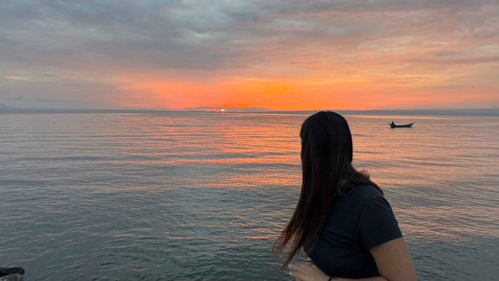 A sunset over a calm sea with a boat in the distance. 3