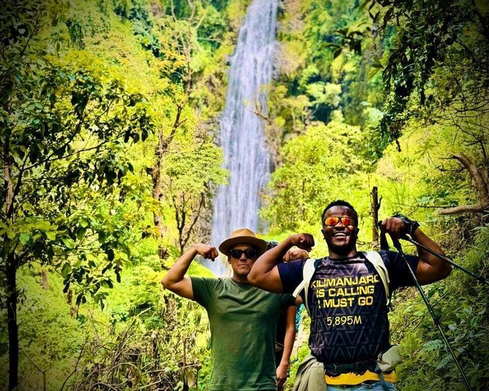 Two people hiking with a waterfall in the background. 3