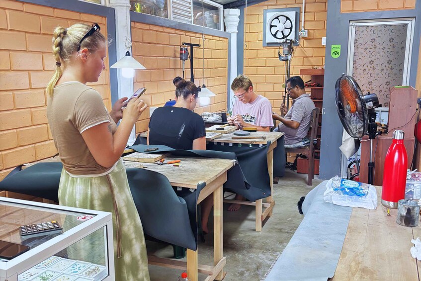 A workshop with brick walls, wooden tables, and people engaged in crafting activities. 5