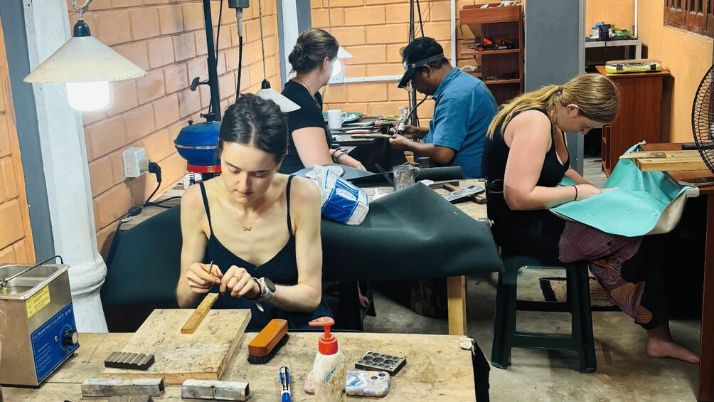 A workshop with people engaged in leather crafting activities. 4