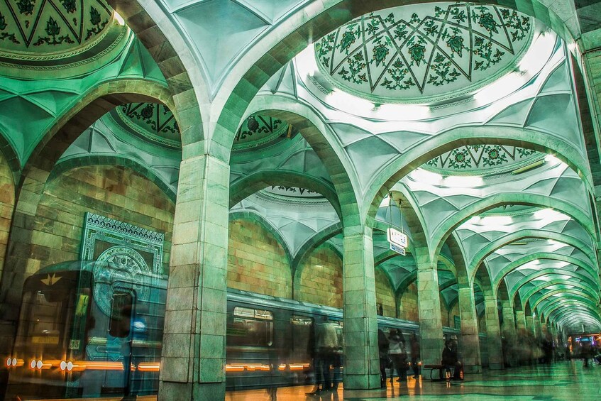 An underground station with arched ceilings and a train. 5