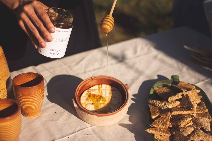 A person pouring honey from a jar onto a bowl of food. 3