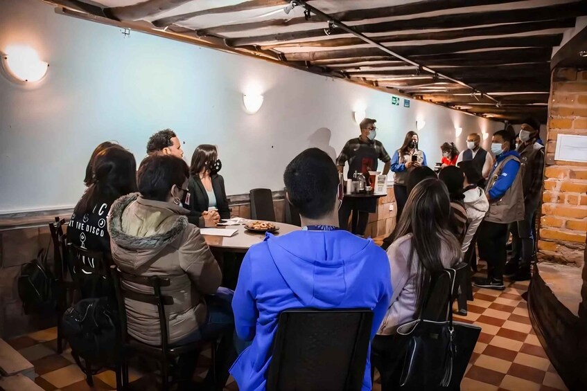 A group of people seated at a table in a restaurant with a checkered floor and brick walls. 3
